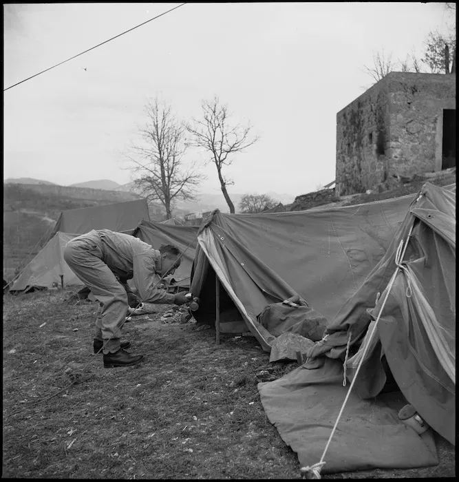 J Jacobson sprays out his bivvy as an anti malarial measure, Italy, World War II - Photograph taken by M D Elias