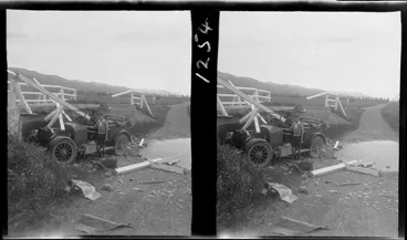 Image: Unidentified teenaged boy beside Ford touring car that has crashed through the barriers of a small wooden bridge on an unknown country road