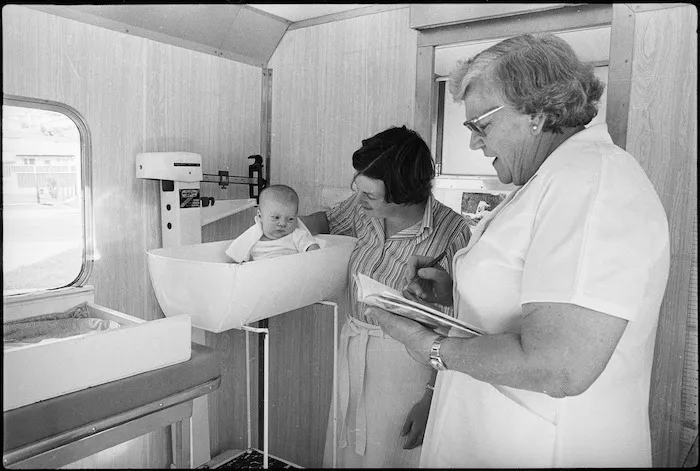 Nurse weighing a baby in a mobile Plunket unit