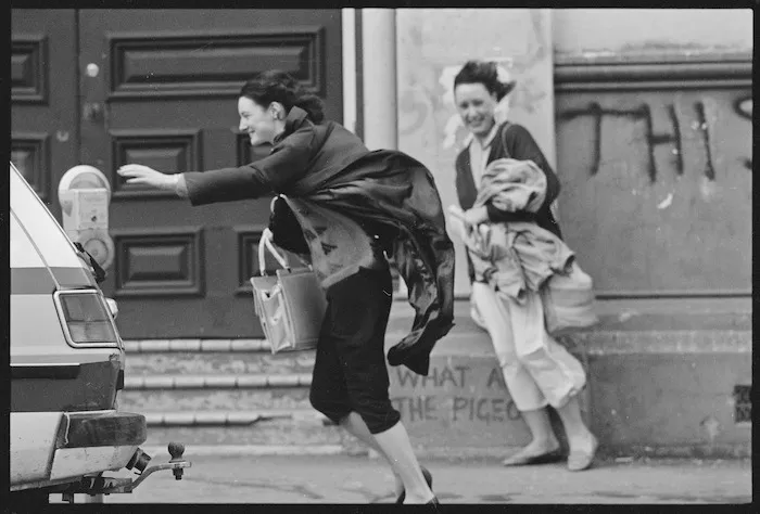 Woman reaching for a parking meter as she battles gale-force north-westerly winds, Wellington - Photograph taken by Ian Mackley