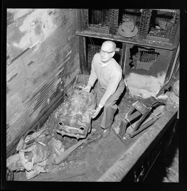 Image: Demolition of Myer's home, Hobson Street, Wellington, showing an unidentified man moving childrens' play equipment, which has been damaged by fire