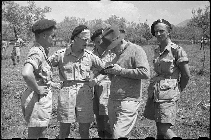 Prime Minister Peter Fraser takes down an address for a trooper of 22 NZ Armoured Regiment near Cassino, Italy - Photograph taken by George Bull