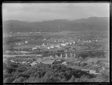 Image: View over the settlement of Kakahi, with sawmill, stacked timber, rail yards and bridge and residential houses with forest covered hills beyond, Manawatu-Whanganui Region