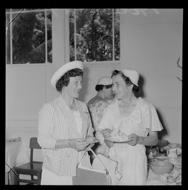 Image: Personalities at the Tauherenikau Racecourse with two unidentified women indoors dressed for the occasion, Wairarapa District