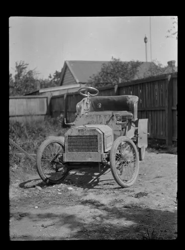 Image: Near front view of a mud covered Ford Model [N?] car within an unknown backyard location, South Island