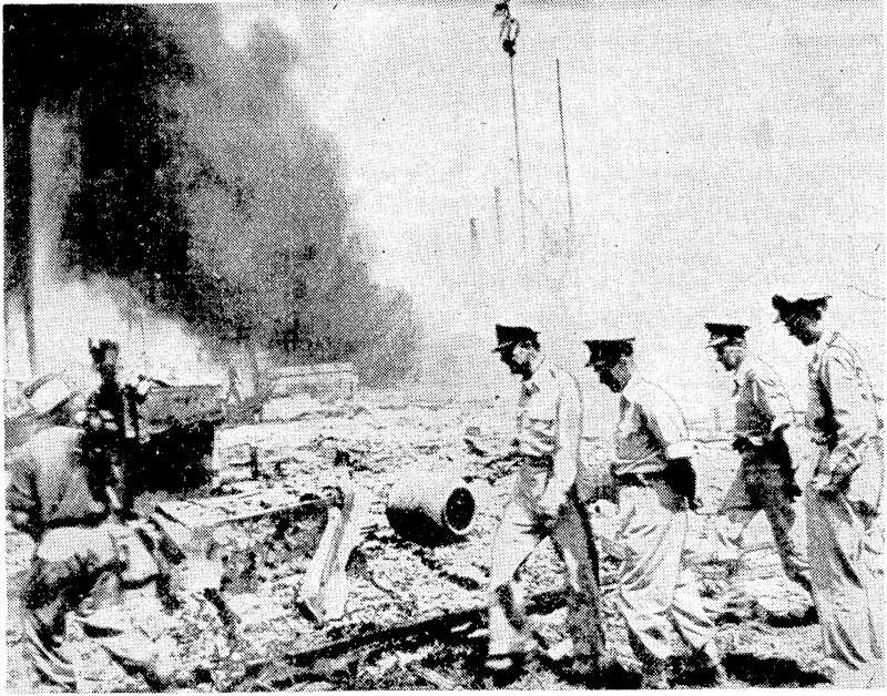 Accompanied by high-ranking Australian officers. General Douglas Mac Arthur, Alliefl commander in the Pacific, viervs the results of pre-invasion shelling of the beach-head at Balik Papan, Borneo. The battle for the great Pandansari oil refineries, situated north of Balik Papan, lasted for more than a iveek, oiving to strong Japanese resistance. (Evening Post, 26 July 1945)