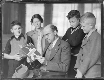 Image: Portrait of G Smith reading Wingspread book with three young boys and a teenaged girl (Betta Models?)