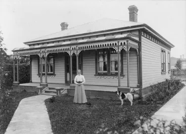 Image: Woman in front of a wooden house