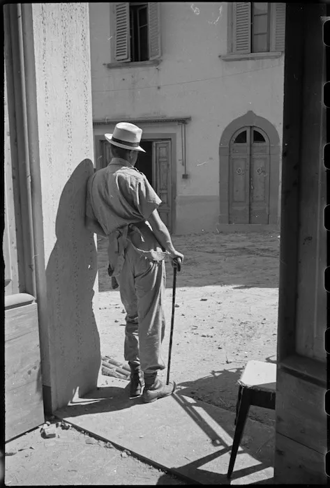 New Zealand soldier tries out a civilian hat in the doorway of a house in San Casciano, Italy, during World War II - Photograph taken by George Kaye