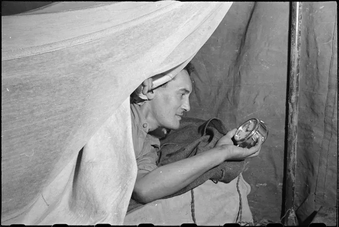 Alarm clock wakes baker J Rika to start at 4 am at 2 New Zealand Field Bakery in Italy, World War II - Photograph taken by George Kaye