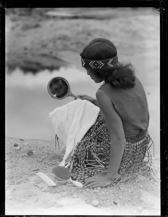 A Maori woman grooming herself by the river, Waikato