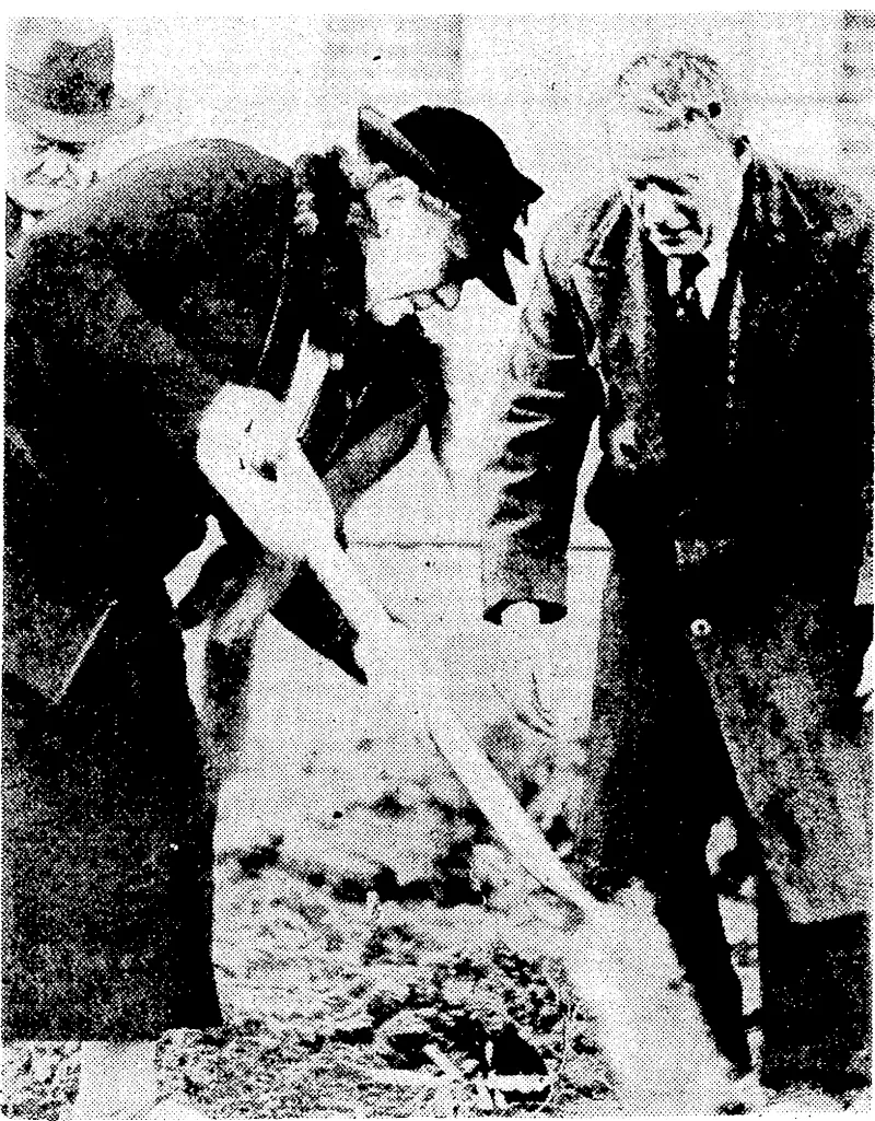 Evening Post" Photo. Mrs. Knox Gilmer, president of the Wellington Horticultural Society, planting a tree at yesterday's Arbor Day function at Mount Cook School. Mr. J. G. MacKenzie, Director of Parks and Reserves, is superintending the proceeding. (Evening Post, 03 August 1939)