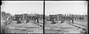 Image: J class locomotive on a railway turntable, with men, women, and children sitting and standing alongside