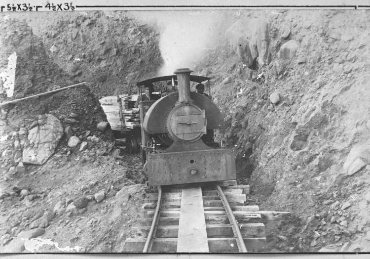 Locomotive on coastal tramway by cliffs, north of Whatipu.