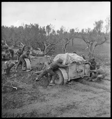 Image: New Zealand artillerymen manhandling guns in heavy mud on the Sangro River front - Photograph taken by George Kaye
