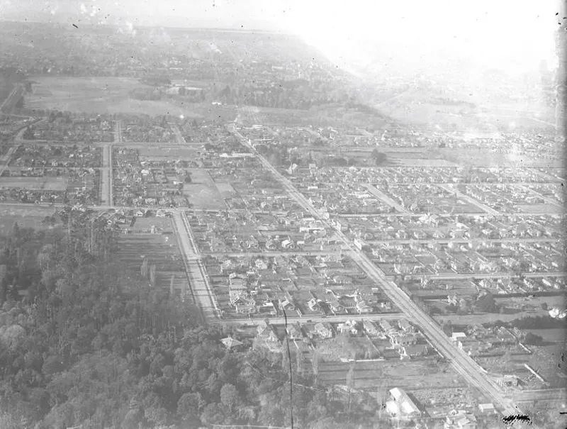 Aerial Obique View Looking East along Riccarton Road towards Hagley Park and Christchurch Public Hospital. Trees in the foreground are Dean's Bush also Known as Riccarton Bush. Christchurch, Canterbury, New Zealand.