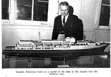 Image: Captain Robertson looks at a model of his ship at the inquiry into the Wahine's loss
