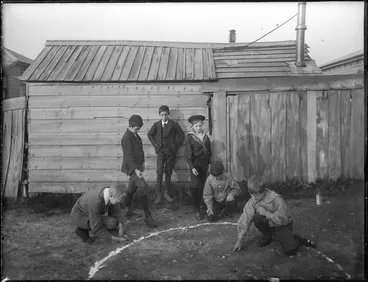 Image: Six boys playing marbles outside