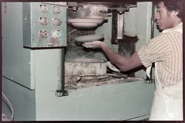 Image: Negative - Man preparing to apply clay to a press moulding machine
