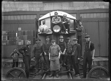 Image: Thomas transmission rail motor car, 1916, with a group of men standing on and beside it.