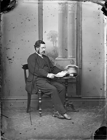 Image: Unidentified man, seated, with an open book