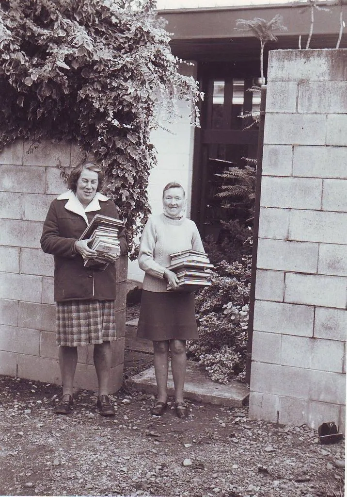 Pam Lyon and Elaine Morse carrying new stock into library, mid 1970's