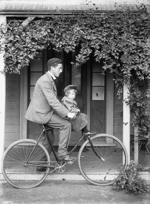 Unidentified man and child on a bicycle