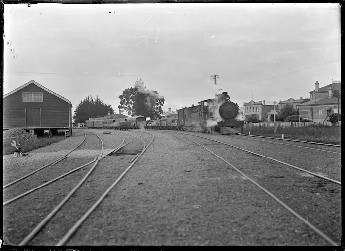 Steam locomotive Class Ua number 177 hauling empty logging wagons past Winton railway station, Southland.