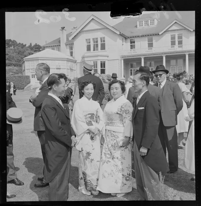 Government House garden party with two unidentified Japanese couples with women in kimonos on the front lawn with other guests, Wellington City