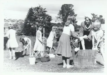 Image: School children learning how to use a mangle in Historical Village during a school visit.