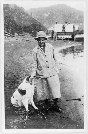 Image: Amy Bock standing on a beach with a dog