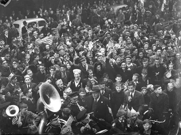 Image: Celebrations. Crowd at WWII, Victory over Europe ( VE ) Day Celebration. Held 9 May 1945, Band at Bottom Passing Through. Christchurch, Canterbury, New Zealand.