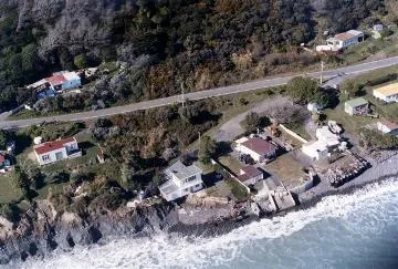 'Threatened homes, Palliser Coast (Te Kopi)' : Photograph