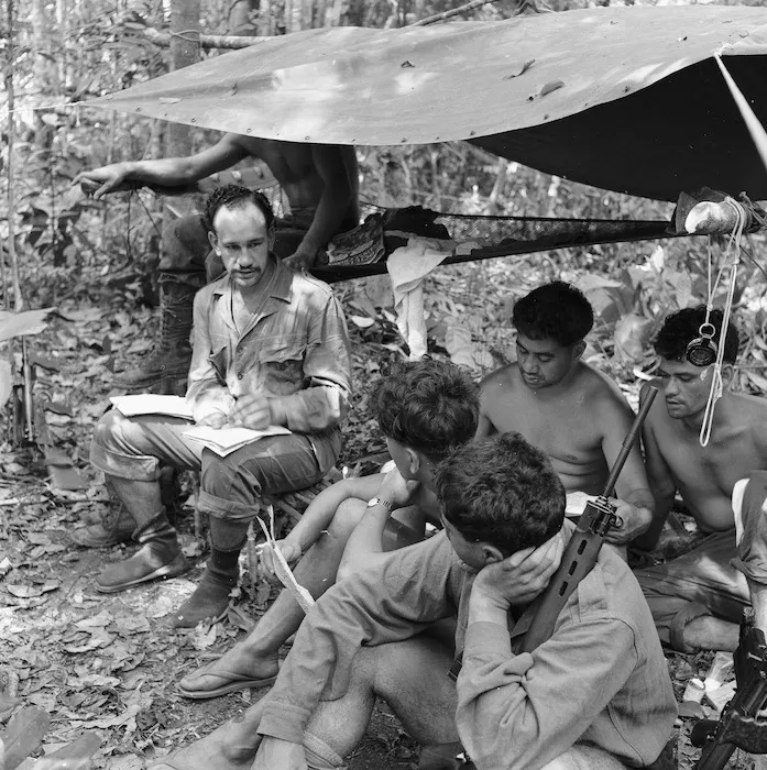 Corporal F H Woods briefing troops, Malayan jungle