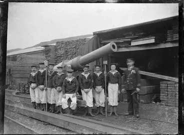 Image: Representation of a cannon beside a group of men dressed as sailors with their officer, ready for procession in Petone to celebrate the end of the South African War