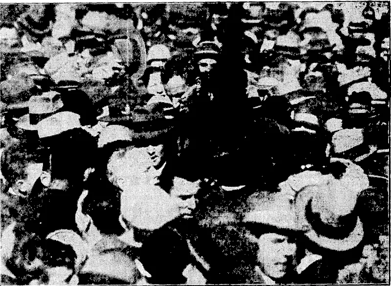 The crowd about to "shoulder" Captain Kingsford Smith (cigarette in mouth) arid Mr. Ulm (with back to camera and close to his chief). : (Evening Post, 12 September 1928)