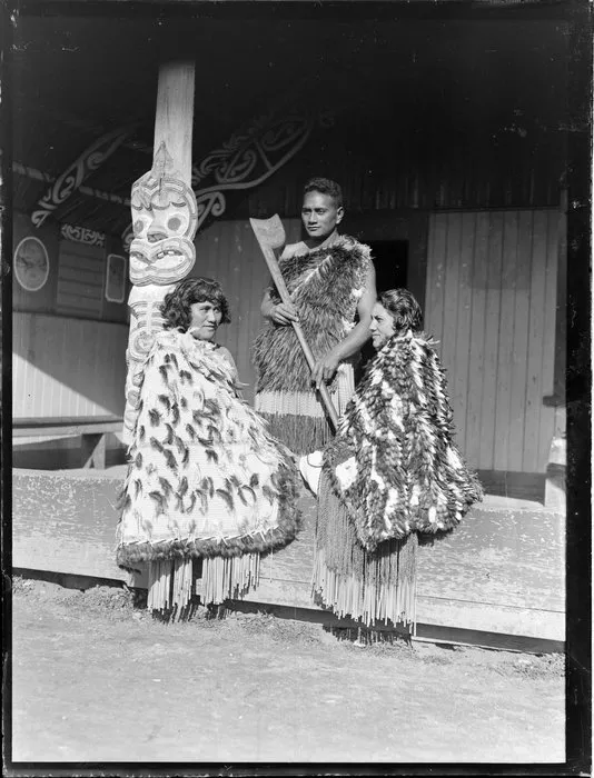 Pura Konui, Mihihi Kuru and Tarihira Mihinui-Northcroft dressed in kakahu and piupiu, at Otūkou marae, Lake Rotoaira