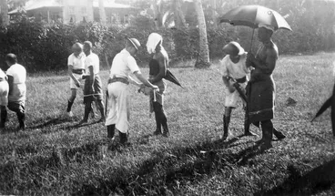 Image: Sailors removing the white band, the insignia of the Mau, from lava lavas