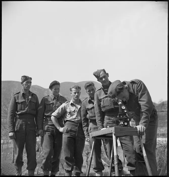 Members of NZ Division attending the Malarial School inspect larvae through a microscope, Italy, World War II - Photograph taken by M D Elias