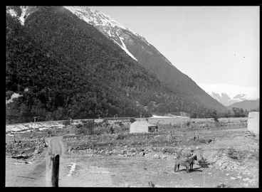 Image: Midland Railway Line, Arthur's Pass, featuring horses, wooden buildings and a wooden railway bridge in the background