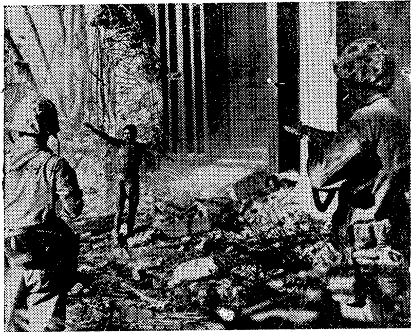A Jap nese soldier,, cornered by U.S Marines, holds out bis arms in surrender in front of a blasted enemy blockhouse in which %0 Japanese were trapped on Narnur Island. . . (Rodney and Otamatea Times, Waitemata and Kaipara Gazette, 03 January 1945)