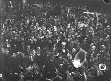 Image: Celebrations. Crowd at WWII, Victory over Europe ( VE ) Day Celebration. Held 9 May 1945, Band at Bottom Passing Through. Christchurch, Canterbury, New Zealand.