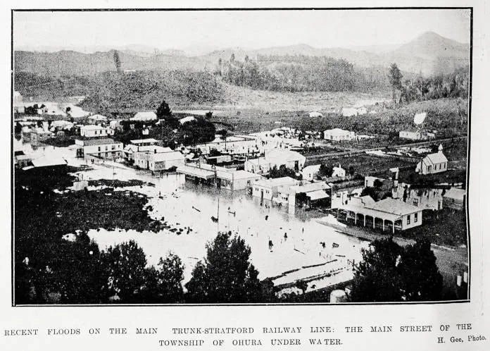 Recent floods on the Main Trunk-Stratford railway line: the main street of the township of Ohura under water