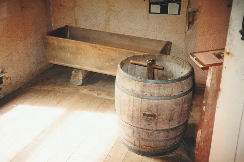 The laundry in Maher-Gallagher Cottage in the Howick Historical Village. Showing a tub and wooden washing machine.
