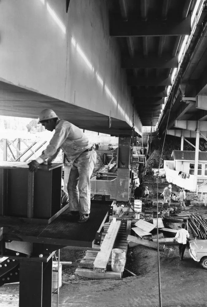 Workmen under the bridge extensions.