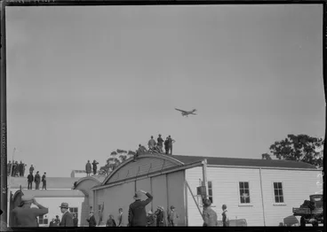 Image: Arrival of the Southern Cross at Christchurch. Plane in flight, over hanger