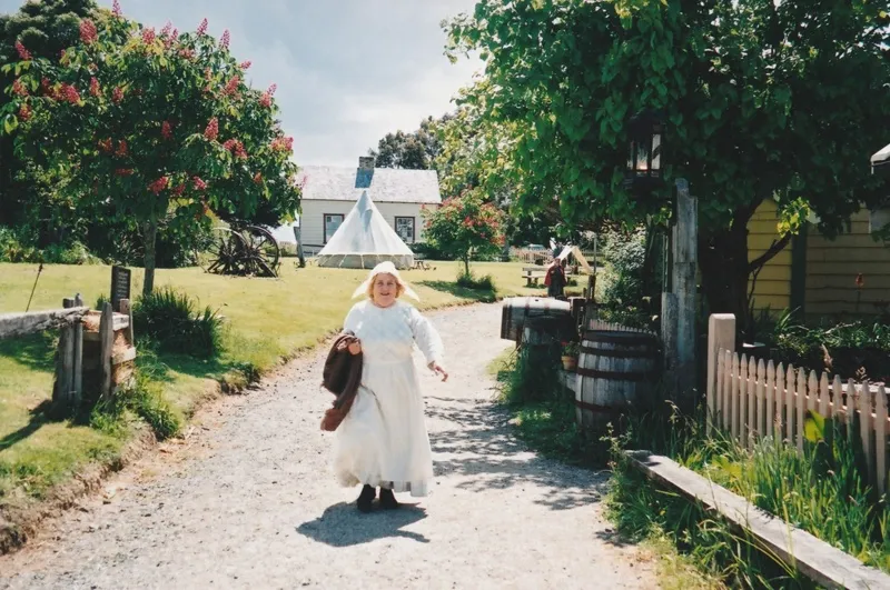 Margaret Robinson in costume walking down Church Street at Howick Historical Village.