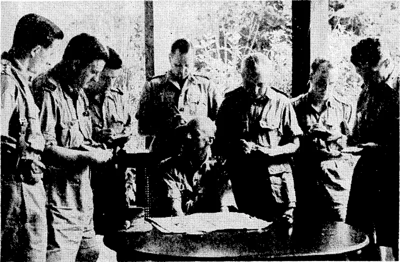 Major-General Gordon Bennett, G.O.C. the Australian Forces in Malaya, giving war correspondents the story of the first A.I.F. contact with the Japanese. From the left, Captain B. Curtis, British conducting officer; W. Knox-, Sydney "Mirror"; H. Standish,"Sydney Morning Herald"; /. Fitchett, official A.I.F. correspondent; H. Gourd, "United Press"; H. A. Stokes, Australian Broadcasting Commission; and Tom . , Fairhall, "Sydney Daily Telegraph." . (Evening Post, 14 February 1942)