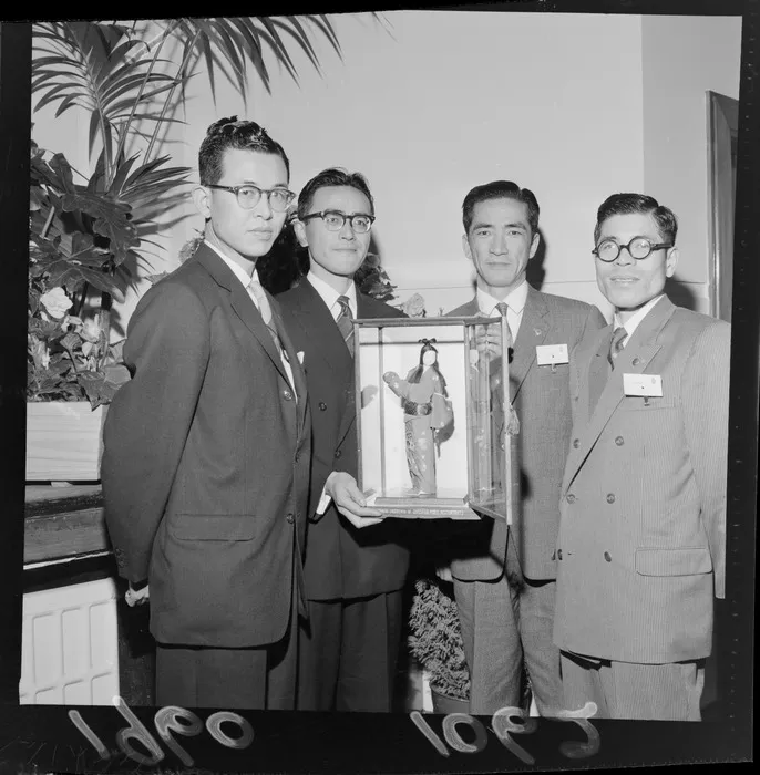 Unidentified Japanese accountants, with Japanese doll in glass case, gift for New Zealand accountants