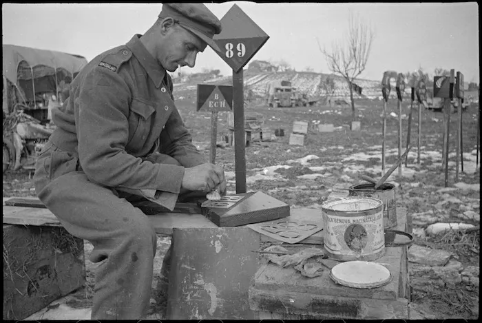 F J Andrews constructing and painting signs for use by NZ Division on the Italian Front, World War II - Photograph taken by George Kaye